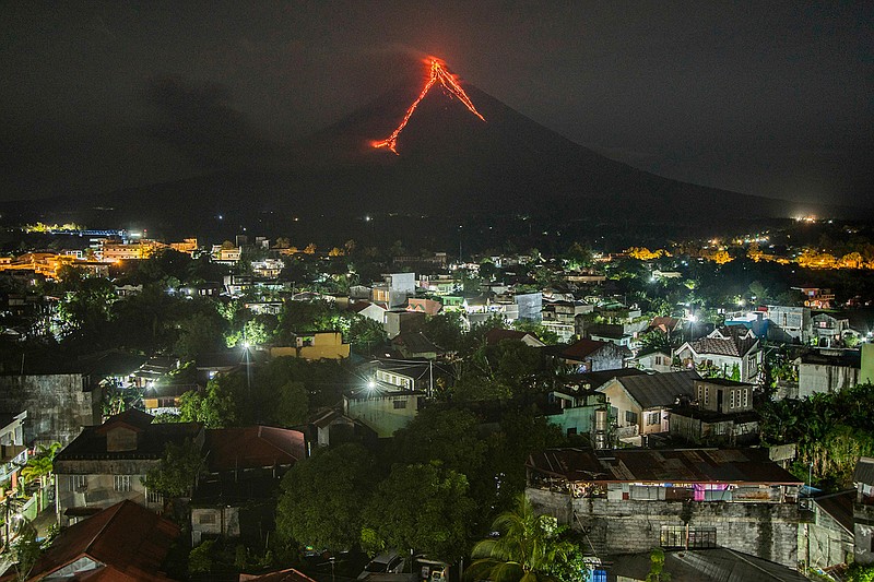 Lava cascades down the slopes of the Mayon volcano seen from Legazpi city, Albay province, 340 kilometers (210 miles) southeast of Manila, Philippines, Tuesday, Jan. 16, 2018. Over 9,000 people have evacuated the area around the Philippines' most active volcano as lava flowed down its crater Monday in a gentle eruption that scientists warned could turn explosive. 