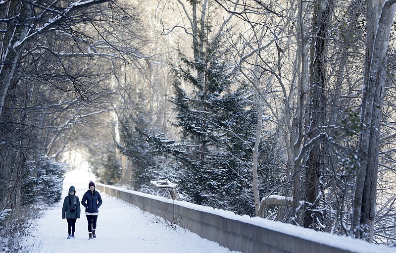 Brooke Meadows, left, and Alex Ondrus go for a walk Tuesday, Jan. 16, 2018, in Radnor Lake State Park, Nashville, Tenn. A winter storm brought snow and cold temperatures to the area, causing the closing of schools and businesses. (Mark Humphrey)