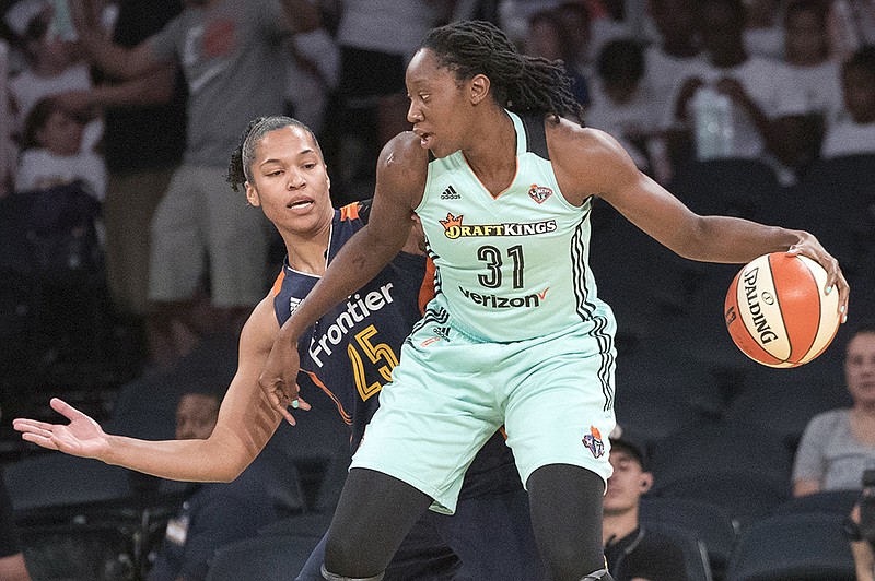 FILE - In this July 19, 2017, file photo, New York Liberty center Tina Charles (31) drives to the basket against Connecticut Sun forward Alyssa Thomas (25) during the first half of a WNBA basketball game in New York. Charles, who is from New York, has made it clear she does not want to leave her hometown.