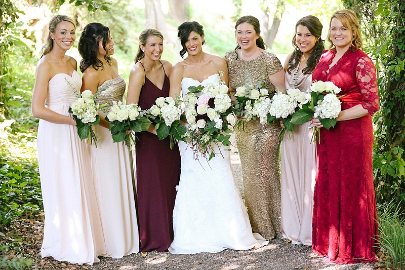 In this May 2016 photo provided by Leah Moyers Photography, the bridal party of Sydney Broadhead of Nashville, Tenn., poses at her wedding in Ashville, N.C. Broadhead allowed her bridesmaids to choose their own dresses, though she stayed in the loop on their plans and was the final arbiter. Mismatching bridesmaids dresses has become more popular in recent years. (Leah Moyers Photography via AP)