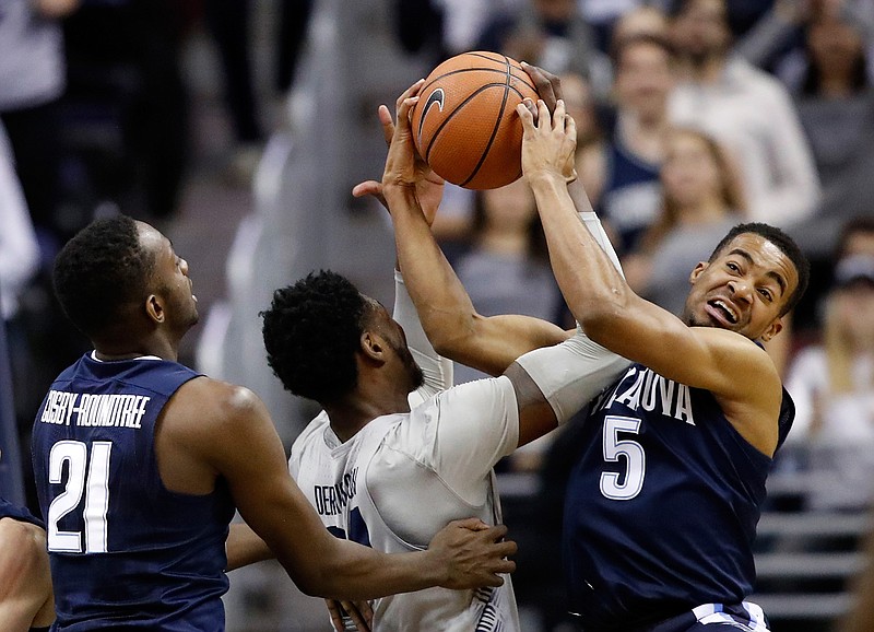 Georgetown forward Marcus Derrickson (24) and Villanova guard Phil Booth (5) go for the rebound with Villanova forward Dhamir Cosby-Roundtree (21) nearby, during the first half of an NCAA college basketball game, Wednesday, Jan. 17, 2018, in Washington. (AP Photo/Alex Brandon)