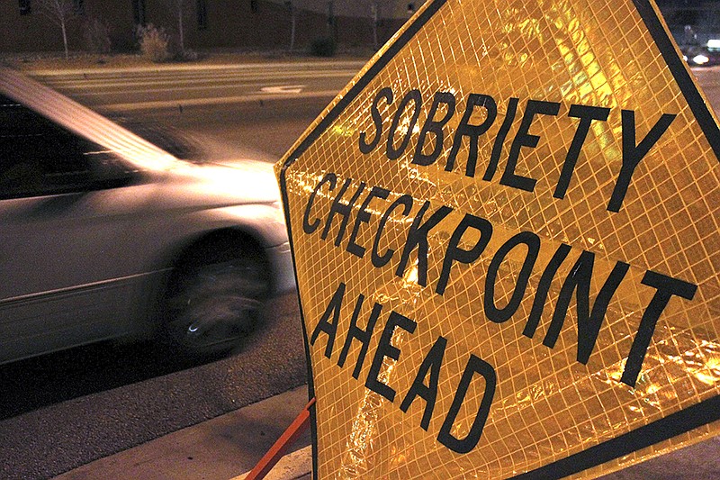 In this Dec. 29, 2011 file photo, a car approaches a sobriety checkpoint set up along a busy street in Albuquerque, N.M. A prestigious scientific panel is recommending that states significantly lower their drunken driving thresholds as part of a blueprint to eliminate the "entirely preventable" 10,000 alcohol-impaired driving deaths in the United States each year.
