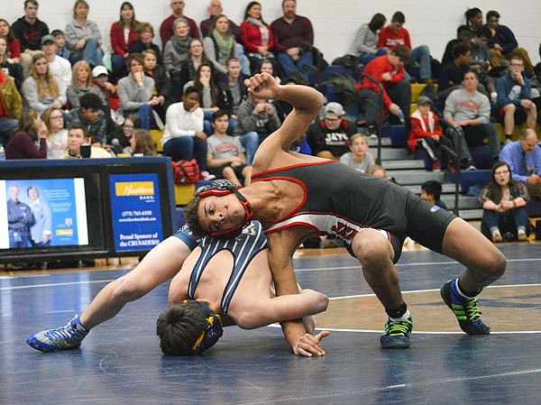 Jefferson City's Xavier Adams attempts to escape the reach from Helias' Evan Winder during Wednesday night's dual at Rackers Fieldhouse.