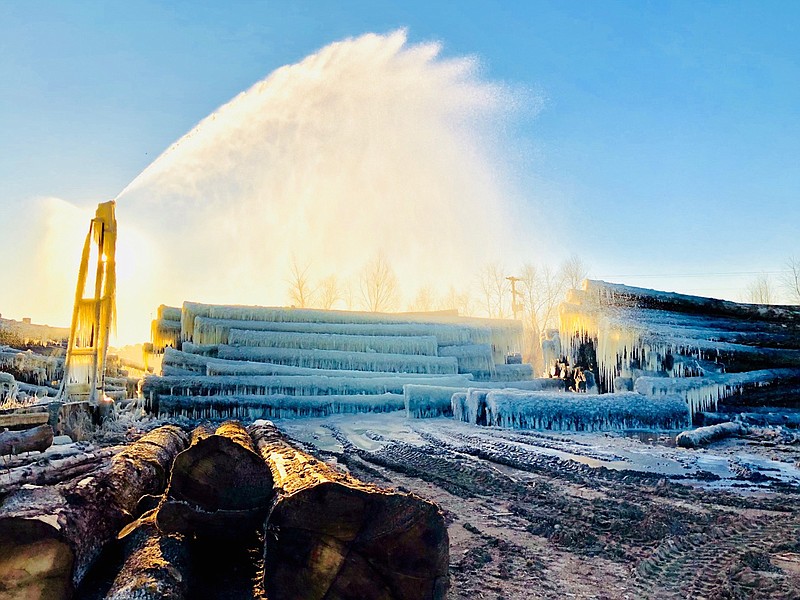 Ice forms mysterious cave-like shapes on logs Wednesday morning at Phillips Forest Products sawmill in DeKalb, Texas. The logs were sprayed with water to protect them from drying out. (Photo submitted by Chuck Phillips)