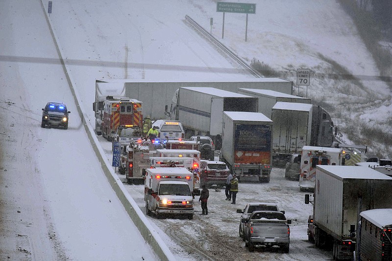 Emergency personnel remove patients for transport to area hospitals at the scene of a multi-vehicle wreck on Interstate 65 near Bonnieville, Ky., Tuesday, Jan. 16, 2018. The wreck shut down the southbound lanes for several hours. Several people were transported from the scene to at least two different hospitals.