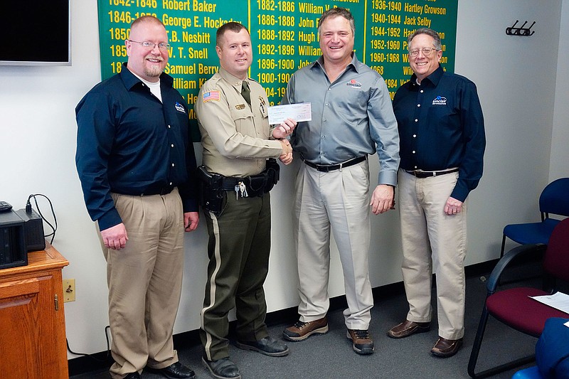 <p>Jenny Gray/FULTON SUN</p><p>An unexpected $15,000 check was handed to Callaway County Sheriff Clay Chism on Friday by Sinclair Research officials. From left are Derek Brocksmith, facility security coordinator and general manager; Chism; company owner Dr. Guy Bouchard; and Jeff White, vice president of finance. Sinclair Research, located northwest of Hatton, employs about 200 people and offers specialty biomedical research services for both humans and animals.</p>