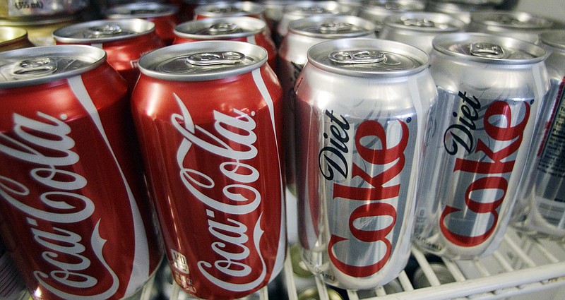 FILE - In this March 17, 2011, file photo, cans of Coca-Cola and Diet Coke sit in a cooler in Anne's Deli in Portland, Ore. The Coca-Cola Co. plans to help collect and recycle a bottle or can for every one that it sells by 2030. The beverage company is also working on making all of its packaging 100 percent recyclable worldwide.  Coca-Cola said Friday, Jan. 19, 2018,  that it's creating bottles with more recycled content by developing plant-based resins.  (AP Photo/File)