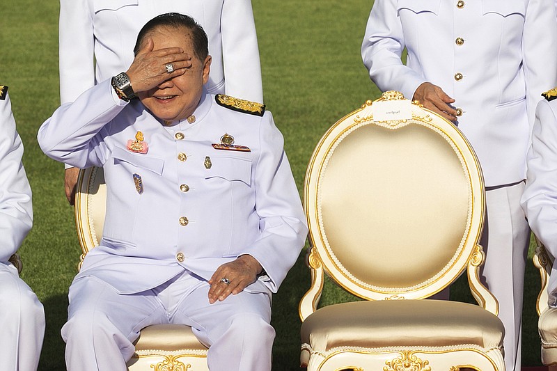 In this Dec. 4, 2017, photo, Deputy Prime Minister Prawit Wongsuwan raise his hand to shade the sun wearing a luxury watch and diamond ring during ceremony Government house. Prawit has so far been spotted wearing a total of 25 opulent time-pieces, none of which appears on his last declaration of assets. (AP Photo/Krit Phromsakla Na Sakolnakorn)
