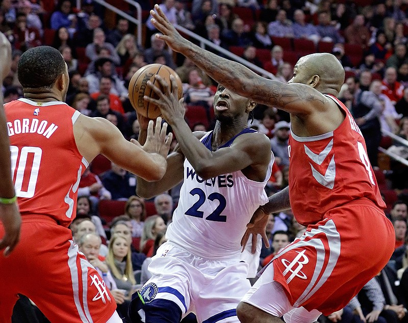 Minnesota Timberwolves forward Andrew Wiggins (22) looks to pass the ball between Houston Rockets guard Eric Gordon (10) and forward PJ Tucker (4) during the first half of an NBA basketball game Thursday, Jan. 18, 2018, in Houston. (AP Photo/Michael Wyke)