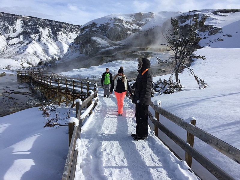 James Kristy and Ginger Lee of Palm Beach County, Fla., walk the boardwalk at Yellowstone National Park’s Mammoth Hot Springs on Saturday, Jan 20 2017  Visitors can still ride snowmobiles and snow coaches into Yellowstone National Park to gaze at the geysers and buffalo herds, despite the federal government shutdown. (AP Photo/Matthew Brown)