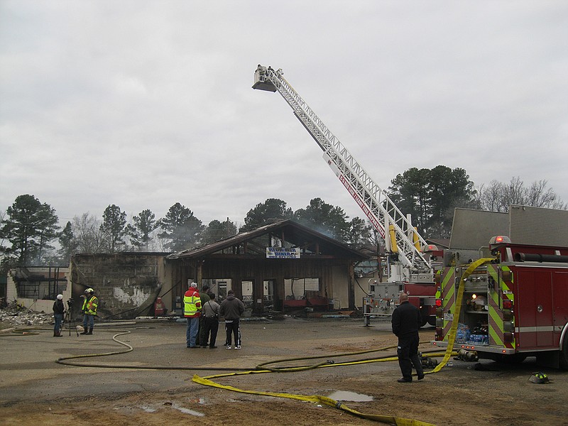Bowie County volunteer firefighters gaze at the gutted and burned ruins of the Redwater Diner after a fire destroyed the eatery early Friday morning.
