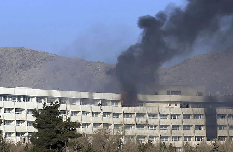Men try to escape from a balcony of the Intercontinental Hotel after an attack in Kabul, Afghanistan, Sunday, Jan. 21, 2018. Gunmen stormed the hotel and sett off a 12-hour gun battle with security forces that continued into Sunday morning, as frantic guests tried to escape from fourth and fifth-floor windows. (AP Photo/Rahmat Gul)