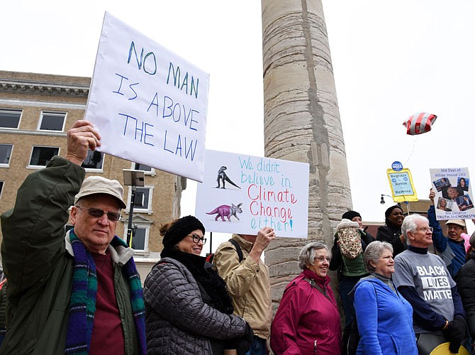 Tony Smith, a member of Jefferson City Area Indivisible, holds up a sign Saturday during the Columbia Solidarity March and Rally outside of the Columbia Municipal Court.