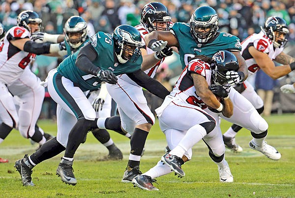 Eagles defensive linemen Fletcher Cox (91) and Vinny Curry (75) close in on Falcons running back Devonta Freeman during last Saturday's divisional playoff game in Philadelphia.