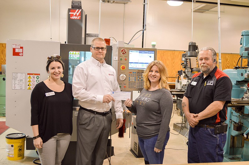 Carey Beevers of Haas Automation Inc., middle left, presents a check for $1,000 to Jennifer Bailey, University of Arkansas Hope-Texarkana dean of Technical and Industrial Professions, to be used for scholarships and National Incident Management System credentialing for students training on the new Haas computer numerical control machine. Also pictured are Anna Powell, director of industry outreach and community education, and Scott Bittle, industrial maintenance faculty member. (Submitted photo)