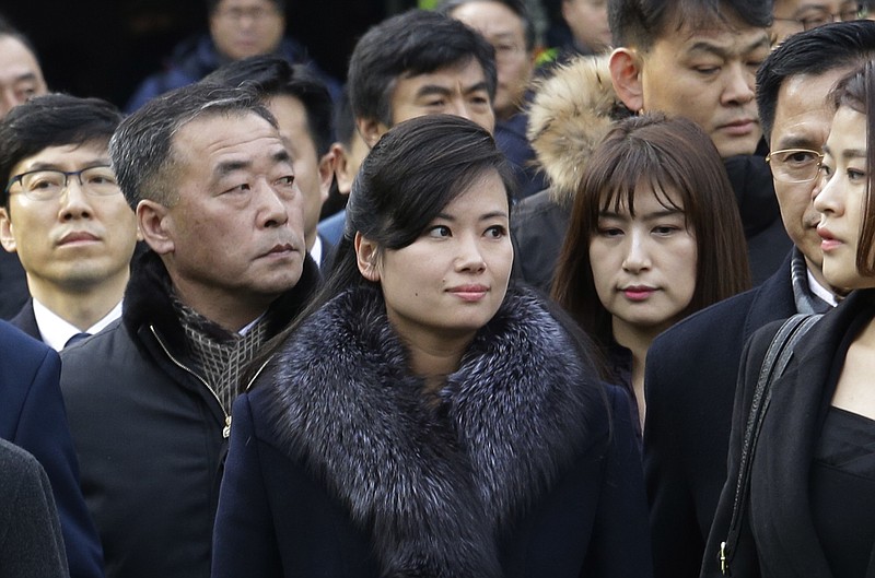 North Korean Hyon Song Wol, center, head of a North Korean art troupe, watches while South Korean protesters stage a rally against her visit in front of Seoul Railway Station in Seoul, South Korea, Monday, Jan. 22, 2018. Dozens of conservative activists attempted to burn a large photo of North Korean leader Kim Jong Un as the head of the North's extremely popular girl band passed by them at a Seoul railway station Monday following a visit to potential venues for performances during next month's Winter Olympics. (AP Photo/Ahn Young-joon)