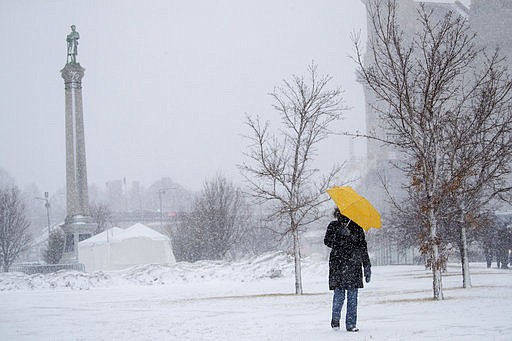 Sarah Wilson walks down the hill along Kellogg Avenue in St. Paul,. Minn., with an umbrella to shield the wind and snow Monday, Jab. 22, 2018. "I walk every day no matter the weather," said Wilson. The Minnesota Department of Transportation is advising against traveling in portions of southwest Minnesota because of white out conditions. The visibility issue extends from Worthington east to Albert Lea and north to Mankato. The roadways involved include portions of Highway 30, Highway 91 and Highway 59. A blizzard warning is in effect for much of south central and southeastern Minnesota.  (Leila Navidi /Star Tribune via AP)