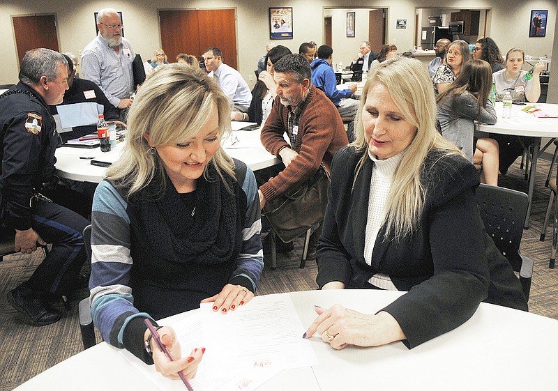 Leslie Broker, left, president of the Council for Drug Free Youth, and Dr. Joy Sweeney go over the night's agenda prior to their annual planning meeting at Hawthorn Bank Thursday evening.