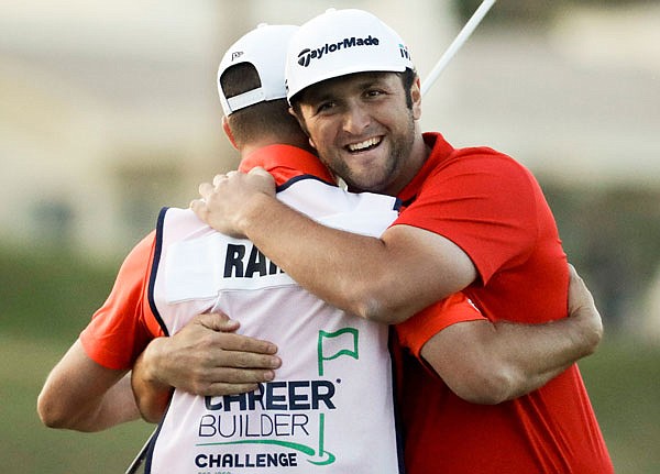 Jon Rahm (right) hugs his caddie Adam Hayes on Sunday after winning the CareerBuilder Challenge on the Stadium Course at PGA West in La Quinta, Calif.