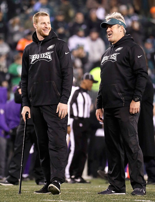Eagles quarterback Carson Wentz watches warmups with head coach Doug Pederson before Sunday's NFC championship game against the Vikings in Philadelphia.