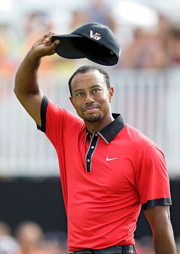 In this Aug. 4, 2013, file photo, Tiger Woods waves on the 18th green after winning the Bridgestone Invitational at Firestone Country Club in Akron, Ohio.