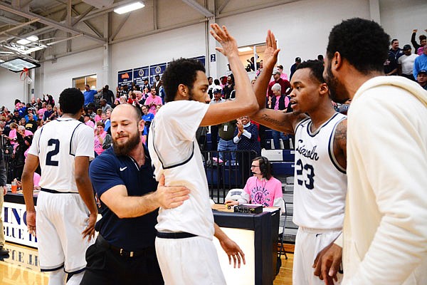 Maurice Mason (center) high-fives Lincoln teammate Amariontez Ivory and gets a pat on the back from strength and conditioning coach Zach Fears after scoring the winning 3-pointer in Saturday afternoon's game against Nebraska-Kearney at Jason Gym.