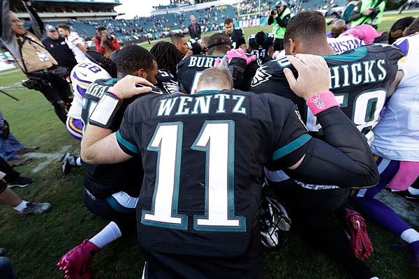 In this Oct. 23, 2016, file photo, Carson Wentz of the Eagles kneels along with other players after a game against the Vikings in Philadelphia.