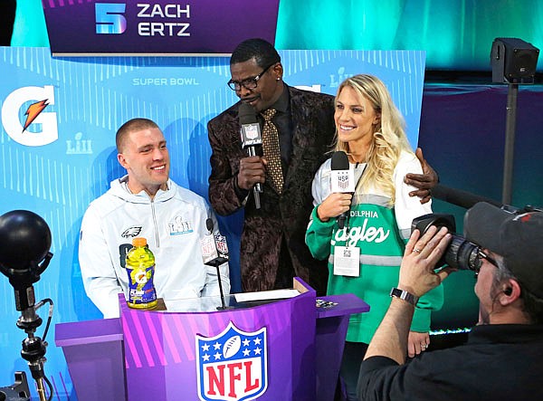 Eagles tight end Zach Ertz (left) is interviewed by Michael Irvin (center) and Zach's wife, Julie Ertz, during Monday's media night for Super Bowl 52 at Xcel Energy Center in St. Paul, Minn. Julie and Zach are currently the sporting world's "It" couple. Julie is a midfielder for the World Cup-winning U.S. national soccer team, while her husband Zach is a tight end for the Super Bowl-bound Eagles.