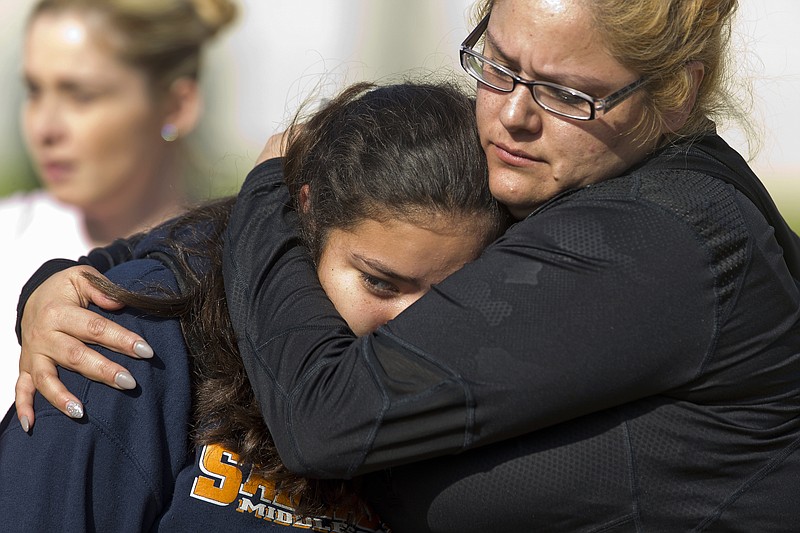 People pick up students after a shooting at the Salvador B. Castro Middle School near downtown Los Angeles Thursday, Feb. 1, 2018. A girl opened fire Thursday in a middle school classroom on Thursday, authorities said. (AP Photo/Damian Dovarganes)