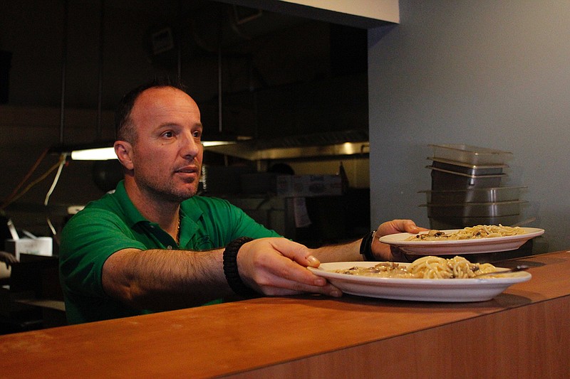 Bida Murseli brings out a couple of freshly prepared meals from the kitchen at Joe's Pizza and Pasta in downtown Texarkana.