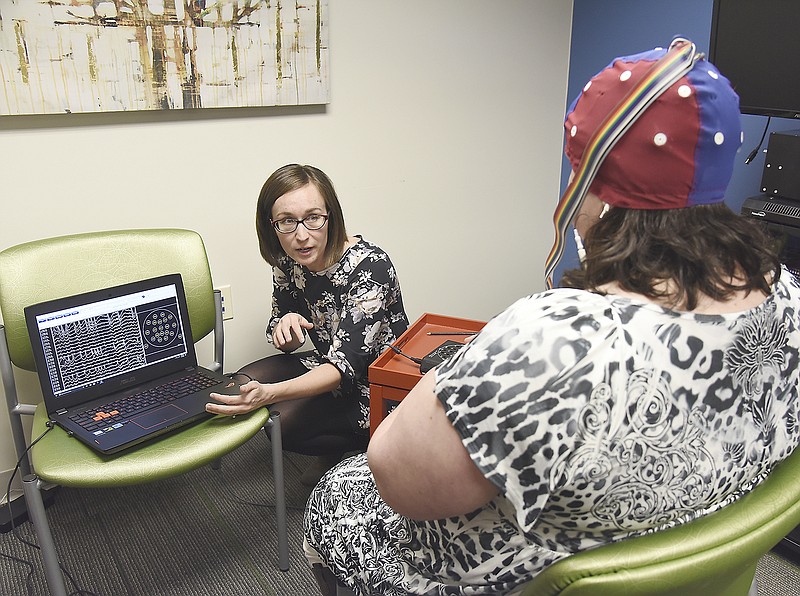 Dr. Jessica Ashley explains to Wendy Reese how the neurofeedback equipment is used and how to read the results. Reese works at Pathways and agreed to go through the process of hooking up the sensors.