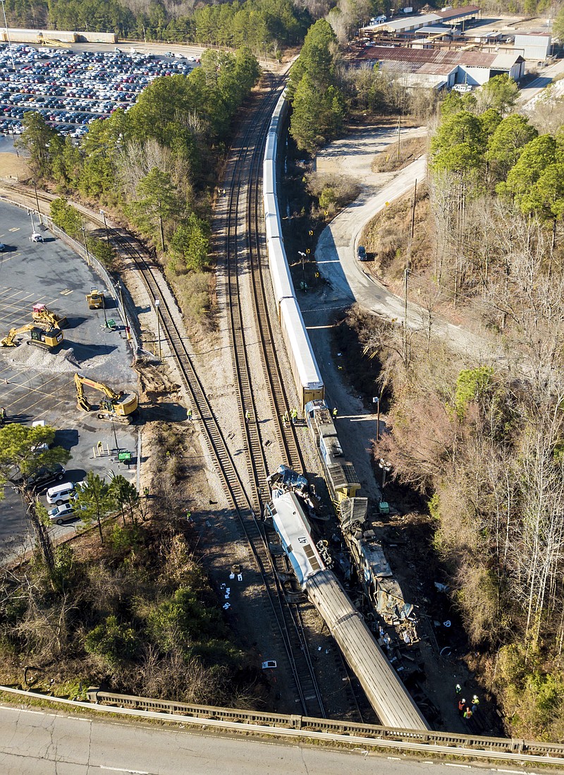 The site of Sunday's early morning train crash between an Amtrak train, bottom, and a CSX freight train, top left, in Cayce, S.C.  Federal investigators are planning to give an update on their probe into a deadly crash between a freight train and a passenger train in South Carolina. The National Transportation Safety Board says on Twitter that the agency will hold a meeting briefing at 4 p.m. Monday, Feb. 5, 2018, near the Columbia Metropolitan Airport.( AP Photo/Jeff Blake)