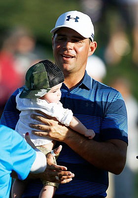 Gary Woodland holds his son, Jaxson, on the 18th green after his one-hole playoff win Sunday at the Phoenix Open in Scottsdale, Ariz.