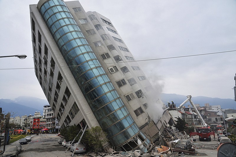 A residential building leans on a collapsed first floor following an earthquake, Wednesday, Feb. 7, 2018, in Hualien, southern Taiwan. Rescue crews continue to try free people from damaged buildings after a strong earthquake hit near Taiwan's east coast and killed at least four people. (Central News Agency via AP)