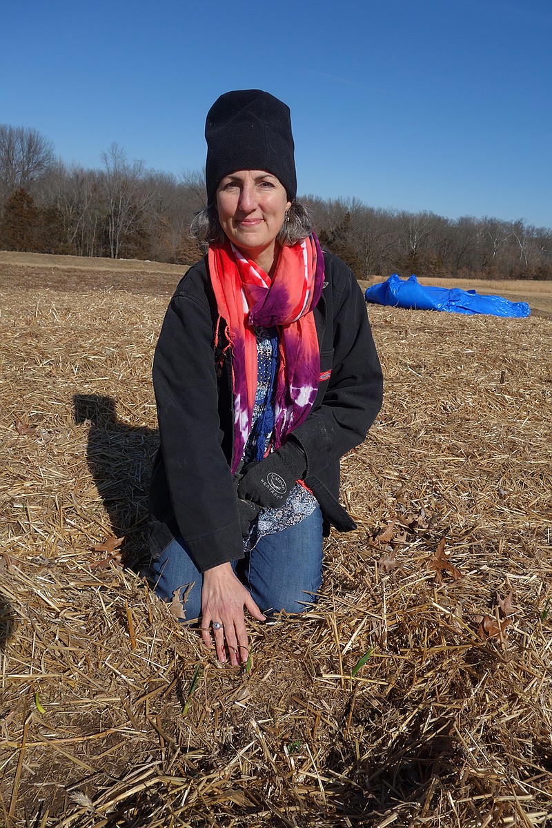 Emily Towne, of Full Plate Farms in Russellville, shows off the garlic growing in her winter garden.