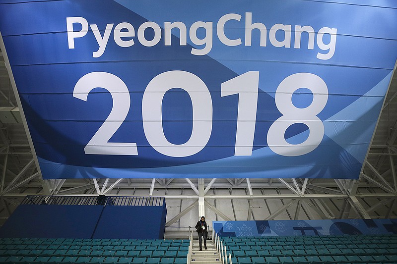 A photographer walks down the steps Tuesday underneath a large banner at the Gangneung Hockey Center ahead of the 2018 Winter Olympics in Gangneung, South Korea. Fresh off the Super Bowl, NBC begins more than two weeks of Winter Olympics coverage on Thursday with a new host, some new wrinkles and the hope that its business model keeps pace with the different ways people experience events on television and online.