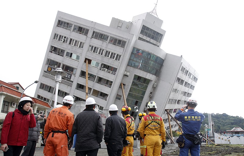 Rescuers from Japan join the searching operation at an apartment building collapsed after a strong earthquake in Hualien County, eastern Taiwan, Friday, Feb. 9, 2018. A magnitude 6.4 earthquake struck late Tuesday night caused several buildings to cave in and tilt dangerously. (AP Photo/Chiang Ying-ying)
