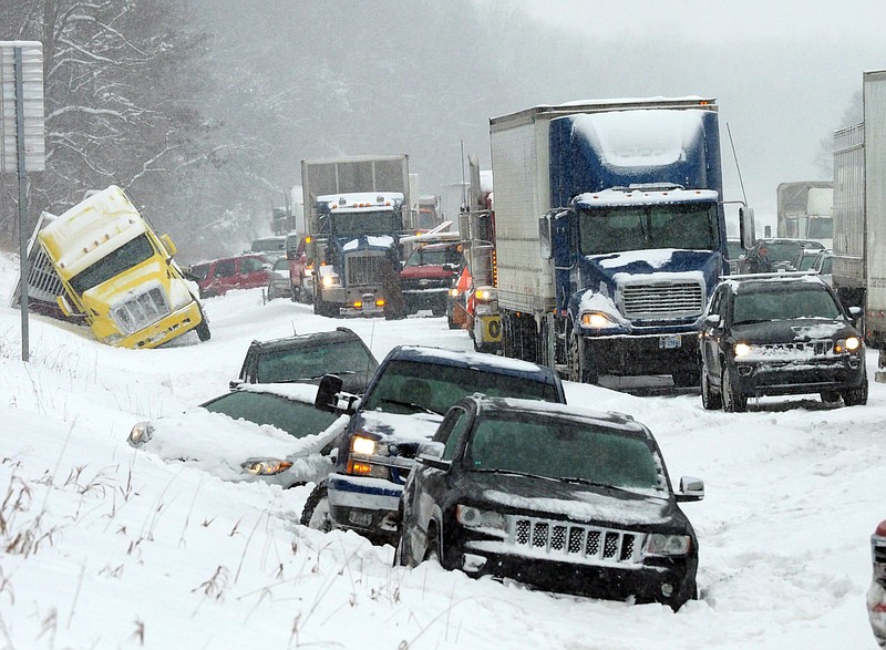 Vehicles rest along the snowbound shoulder along Interstate 94, Friday, Feb. 9, 2018, near Galesburg, Mich., after scores of vehicles were involved in an accident. (Mark Bugnaski/Kalamazoo Gazette-MLive Media Group via AP)