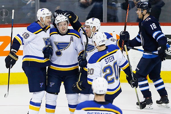 Blues teammates Jay Bouwmeester (19), Vladimir Tarasenko (91), Paul Stastny (26) and Alexander Steen (20) celebrate Tarasenko's goal during the third period of Friday night's game against the Jets in Winnipeg, Manitoba.