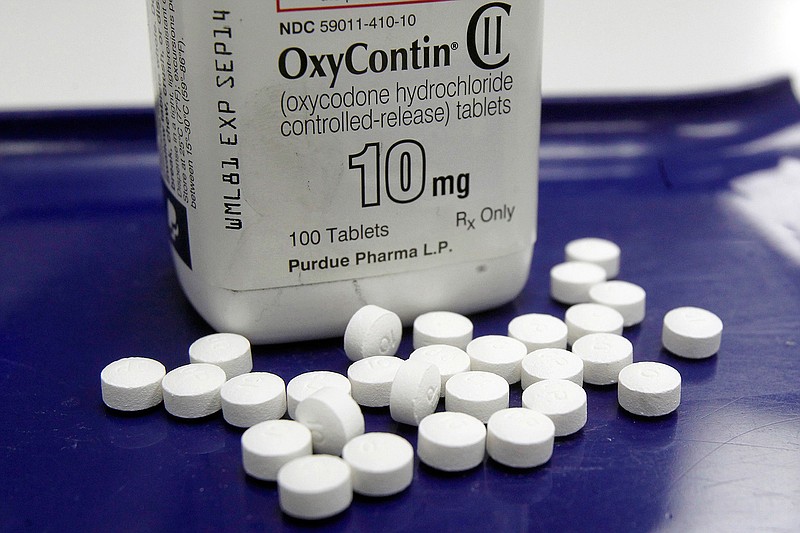 This Feb. 19, 2013 file photo shows OxyContin pills arranged for a photo at a pharmacy in Montpelier, Vt. The maker of the powerful painkiller  said it will stop marketing opioid drugs to doctors, a surprise reversal after lawsuits blaming the company for helping trigger the current drug abuse epidemic.  OxyContin has long been the world's top-selling opioid painkiller and generated billions in sales for privately-held Purdue.  (AP Photo/Toby Talbot, File)