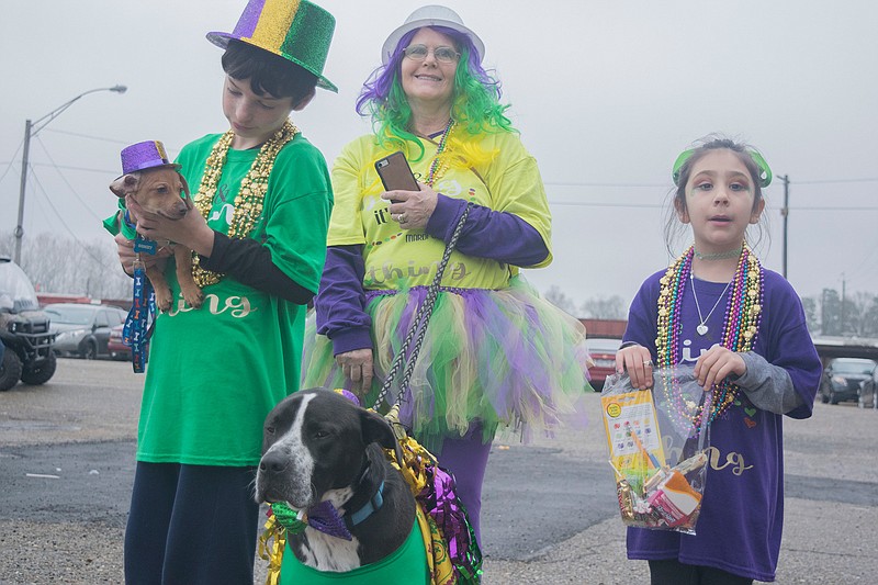 Charlena Simmons, 12-year-old Mason Record and 7-year-old Alora Rivas enjoy the Mardi Gras festivities with their pets Shadow and Kommit  in downtown Texarkana at Front Street Plaza Saturday afternoon. Shadow won the Duke title during the kids and pets parade. (Photo by Tiffany Brown)
