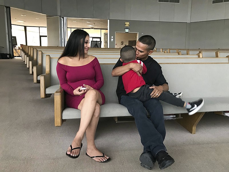 Jesus Berrones holds his five-year-old son, Jayden, as his wife, Sonia, looks on at the Shadow Rock United Church of Christ in Phoenix Monday, Feb. 12, 2018, where he has sought sanctuary to avoid deportation back to his native Mexico. The church is among congregations around the US who allow some special cases of immigrants scheduled for deportation to stay in their sanctuaries until the legal threat has passed. Jayden was diagnosed with leukemia in 2016 and is undergoing a three-year course of chemotherapy. (AP Photo/Anita Snow)