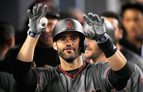 In this Sept. 4, 2017, file photo, J.D. Martinez of the Diamondbacks gestures toward the camera as he stands in the dugout after hitting his fourth home run of the game against the Dodgers in Los Angeles.