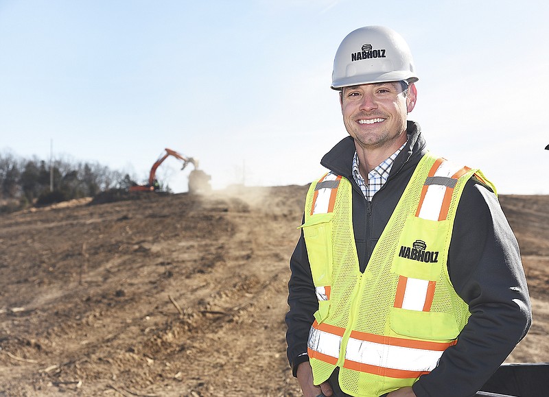 Justin Bolten poses at the construction site of the new yet-to-be named public high school. 