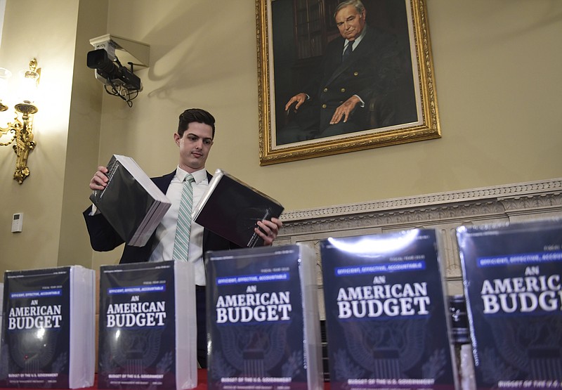 James Knable helps to unpack copies of the President's FY19 Budget after it arrived at the House Budget Committee office on Capitol Hill in Washington, Monday, Feb. 12, 2018. (AP Photo/Susan Walsh)