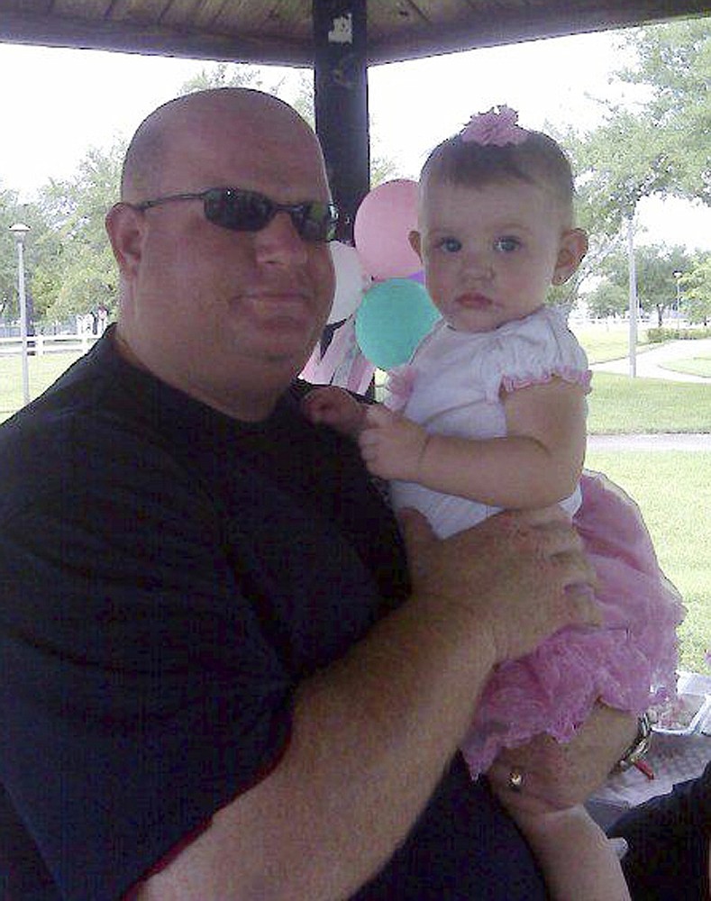 This photo taken from the Facebook page of Aaron Feis shows him with an unidentified girl. Feis, a football coach at Marjory Stonemason Douglas High School in Parkland, Fla., was fatally shot when former student Nikolas Cruz opened fire at the school on Wednesday, Feb. 14, 2018. (Facebook via AP)