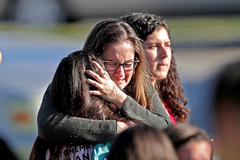 Students released from a lockdown embrace following following a shooting at Marjory Stoneman Douglas High School in Parkland, Fla., Wednesday, Feb. 14, 2018. (John McCall/South Florida Sun-Sentinel via AP)