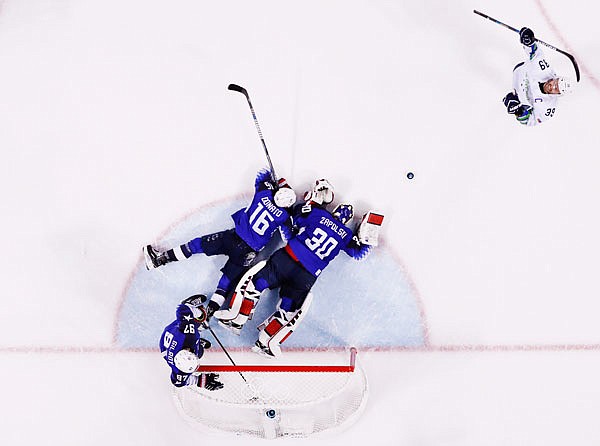 U.S. goaltender Ryan Zapolski (30) reacts with teammates Ryan Donato (16) and Matt Gilroy (97) as Slovenia's Jan Mursak celebrates after scoring the winning goal during overtime Wednesday in the men's hockey preliminary round at the Winter Olympics in Gangneung, South Korea.