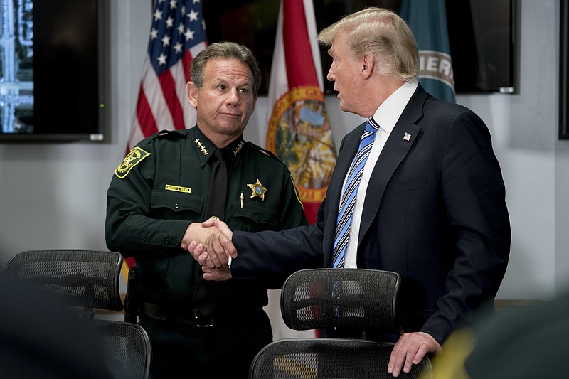 President Donald Trump shakes hands with Broward County Sheriff Scott Israel as he meets with law enforcement officers at Broward County Sheriff's Office in Pompano Beach, Fla., Friday, Feb. 16, 2018, following Wednesday's shooting at Marjory Stoneman Douglas High School, in Parkland, Fla. (AP Photo/Andrew Harnik)