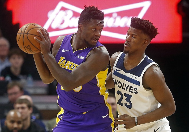 Los Angeles Lakers' Julius Randle, left, looks at Minnesota Timberwolves' Jimmy Butler in the first half of an NBA basketball game Thursday, Feb. 15, 2018, in Minneapolis. (AP Photo/Jim Mone)